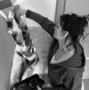 photo noir et blanc de céline leynaud entrain de réaliser une peinture contemporaine de corps humain