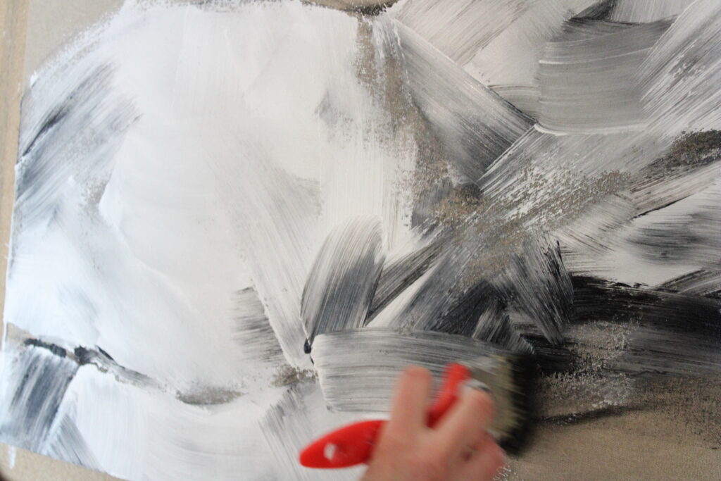 Photo de celine leynaud, artiste peintre en train de donner un coup de pinceau sur une toile de corps dans son atelier en ardeche.
