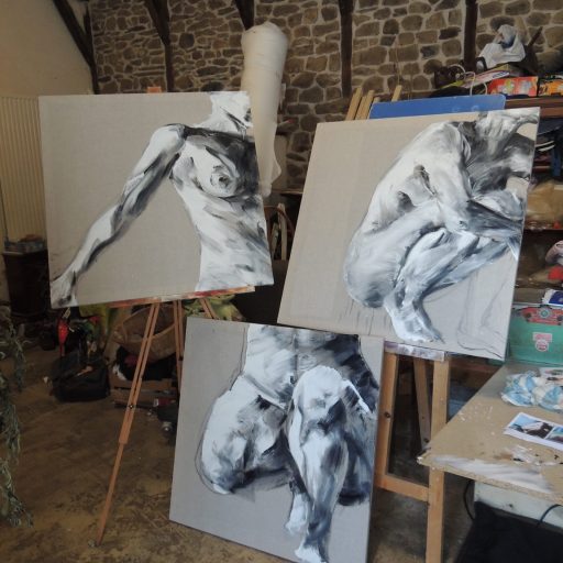 Photo de l'atelier de céline leynaud, artiste peintre contemporaine, de trois toiles en cours d'exécution, représentant des corps humain, nus, en noir et blanc.